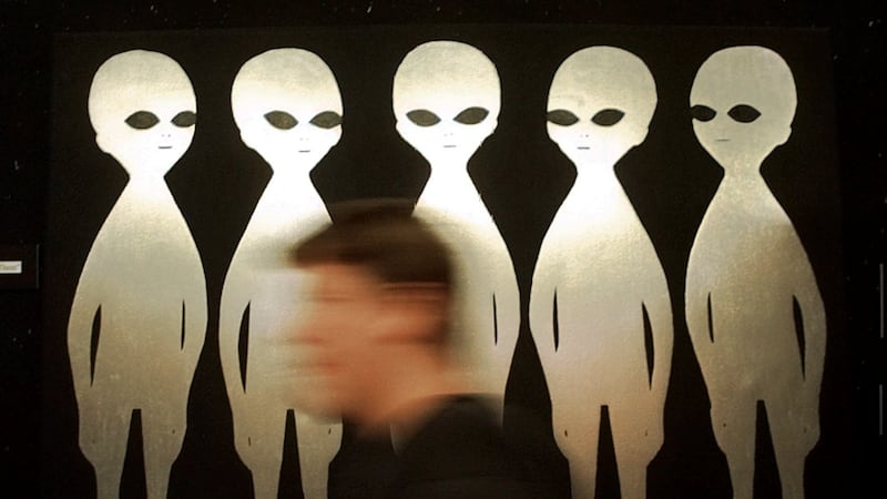 FILE - A patron passes a painting inside the International UFO Museum and Research Center in...