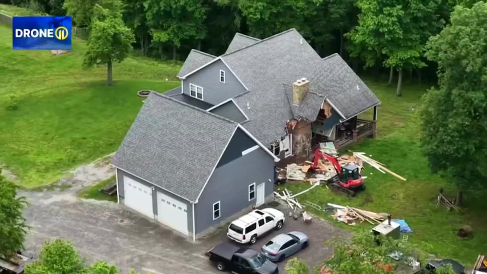 A man is accused of using an excavator to try to demolish his house while his family was inside.